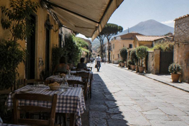 Outdoor lunch tables on a quiet street in modern Pompei