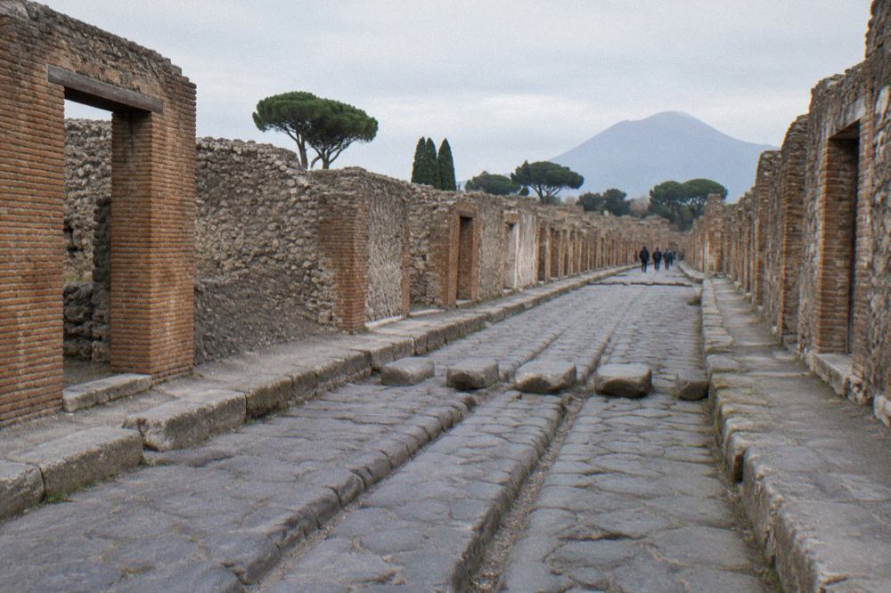 Ancient stone street in Pompeii with deep cart ruts worn into the paving
