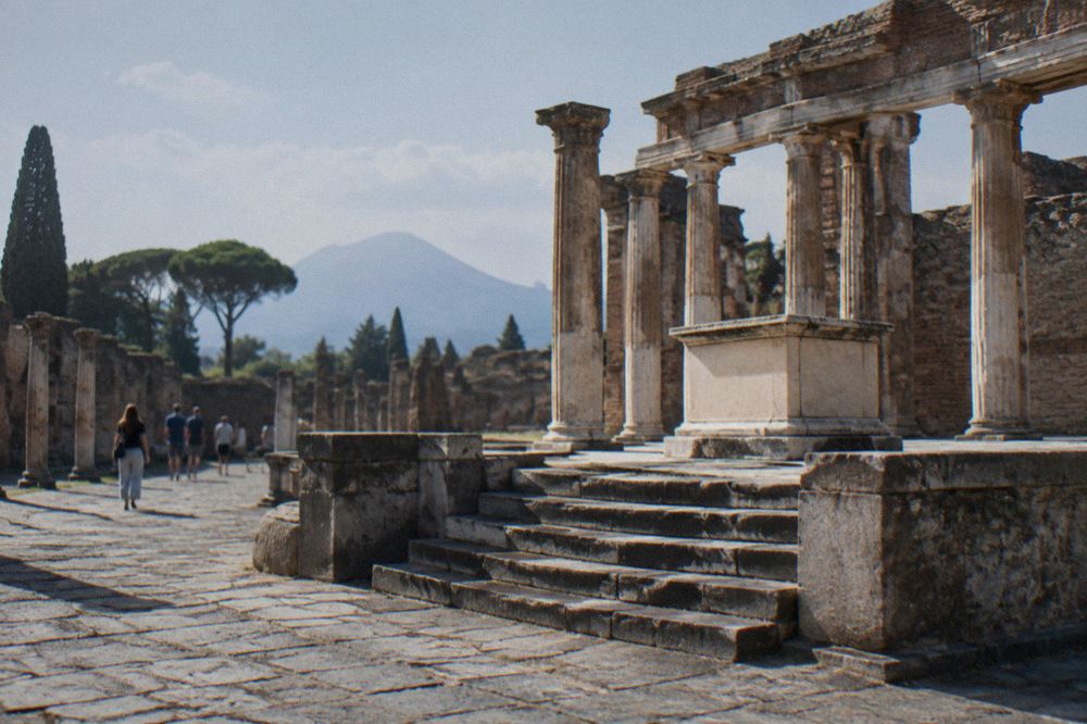 Wide view across the excavated ruins of Pompeii with Mount Vesuvius on the horizon