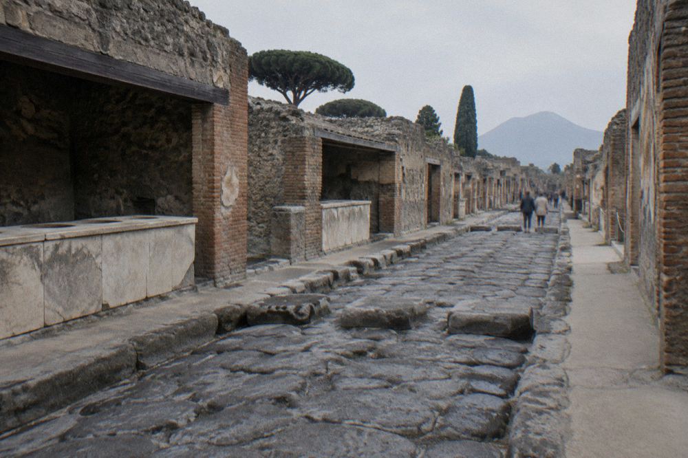 Excavated Roman courtyard with low stone walls and column stumps in warm afternoon light