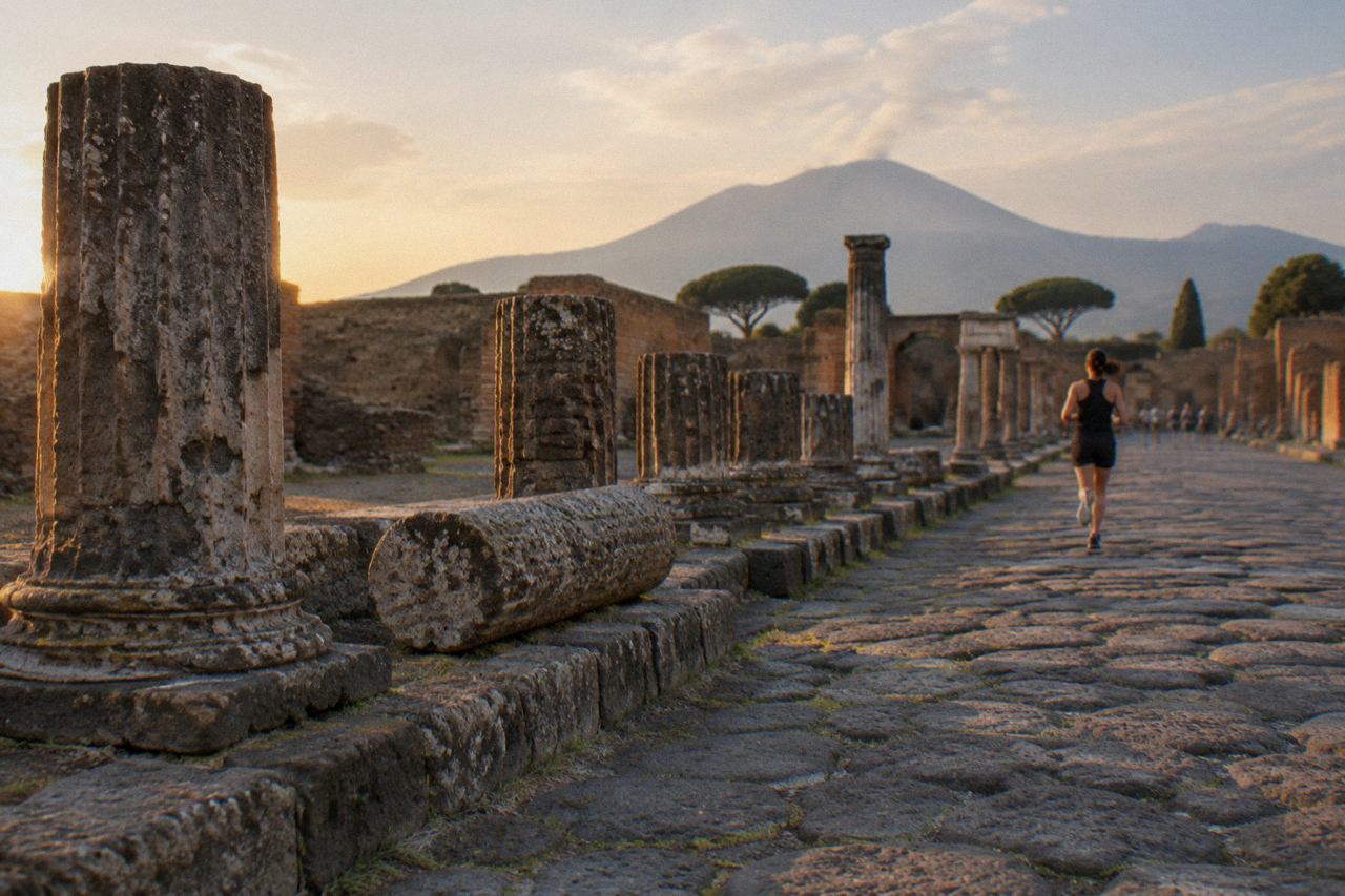 Ancient stone street in Pompeii with worn stepping stones and ruined walls under a clear sky