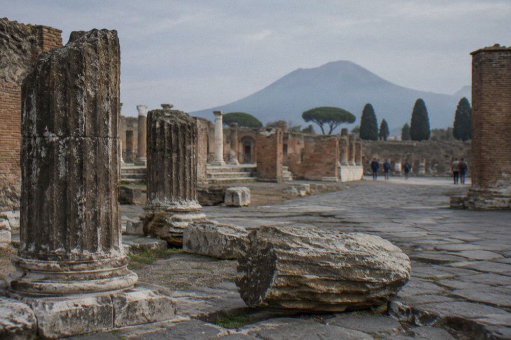 Stone stepping stones crossing an ancient paved street at Pompeii with worn cart ruts