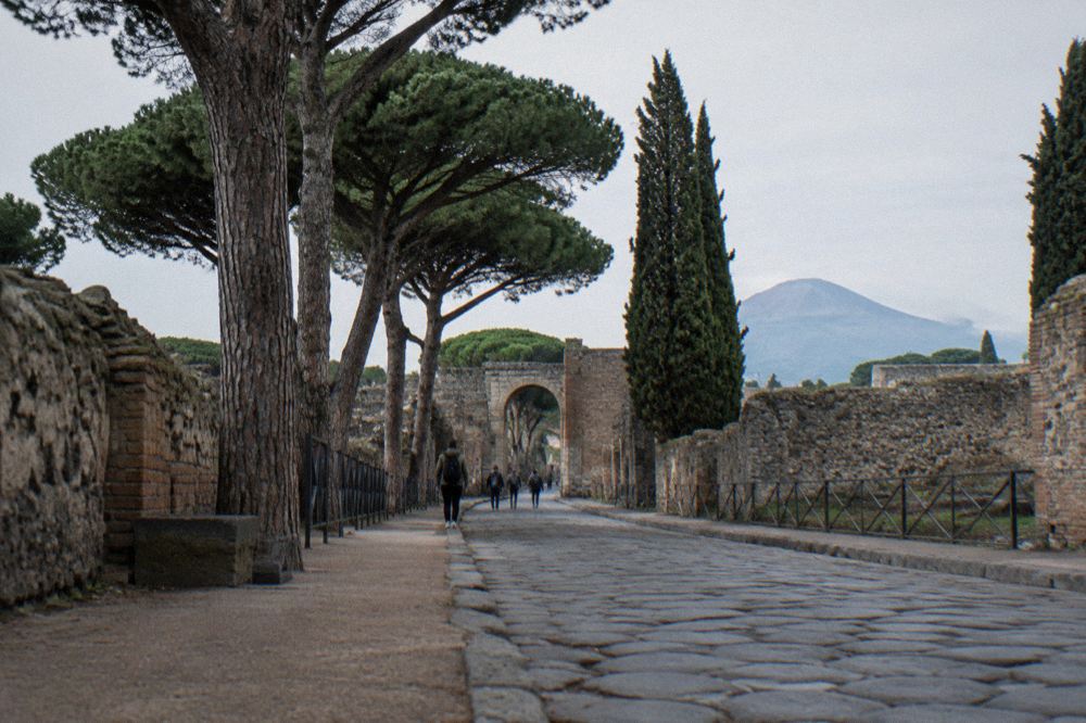An ancient stone gateway entrance to an archaeological site with worn paving underfoot