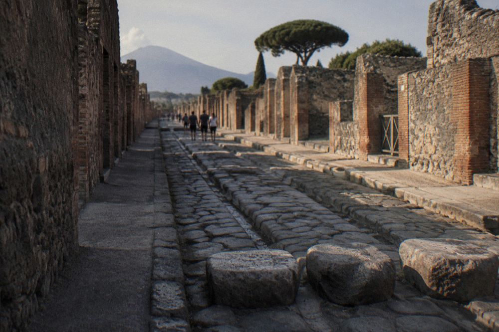 Rough dark volcanic stone slopes of Vesuvius above the Bay of Naples shoreline in clear morning light