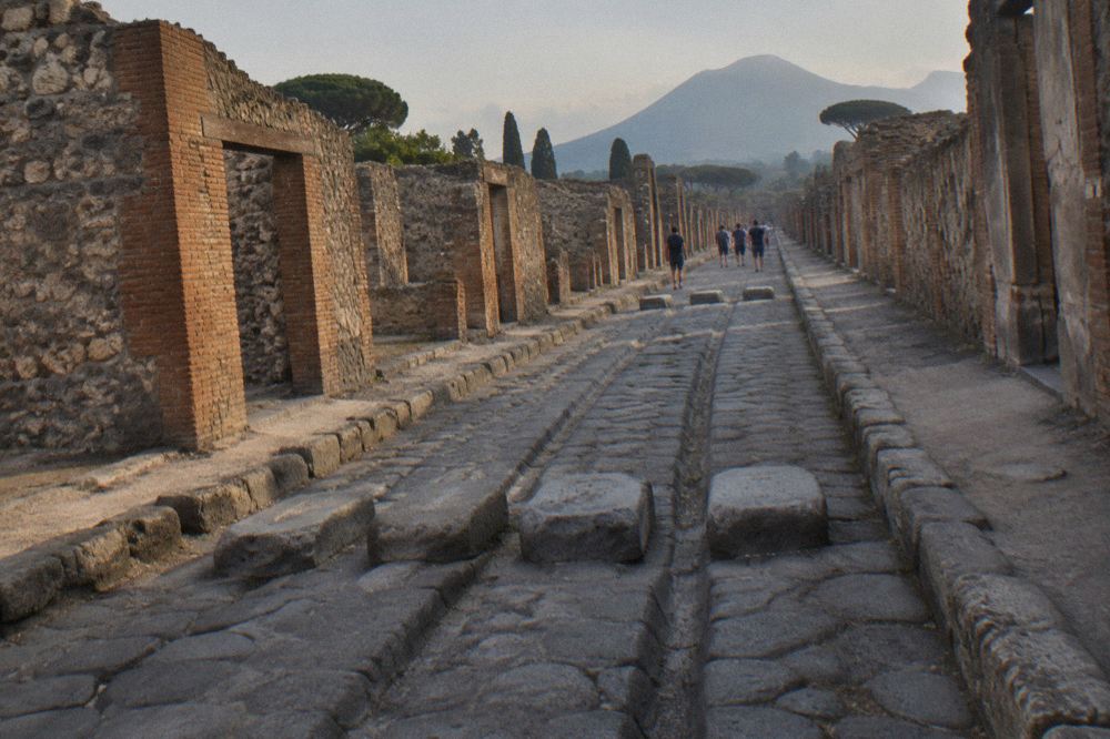 The rim of the Vesuvius crater with dark volcanic rock and a view down into the hollow cone under an open sky