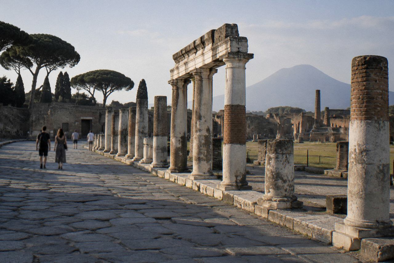 A stone-paved ancient Roman street in Pompeii with deep worn ruts and raised stepping stones