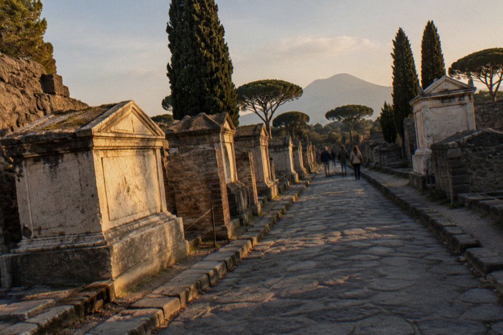 Charred wooden beam preserved as carbon among the stone walls of an excavated house in Pompeii.