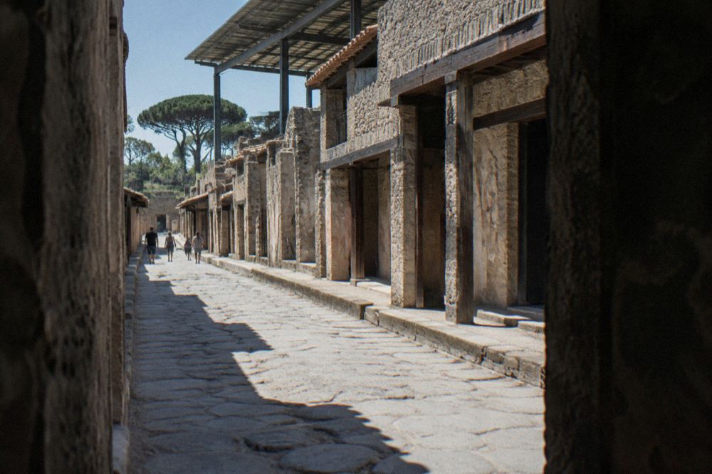 Row of arched boat sheds on the ancient shoreline of Herculaneum beneath a stone wall