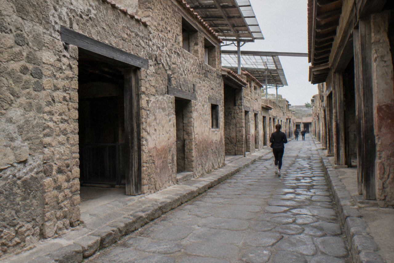 Excavated Roman walls of Herculaneum beneath the modern town of Ercolano on a bright afternoon