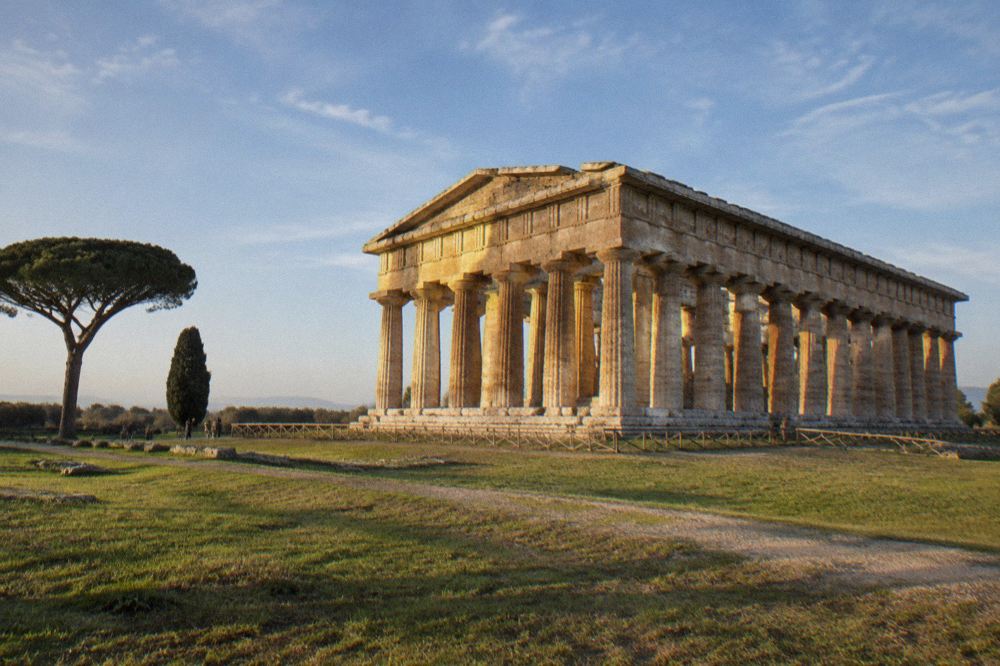 Close view of fluted stone temple columns with capitals against open sky