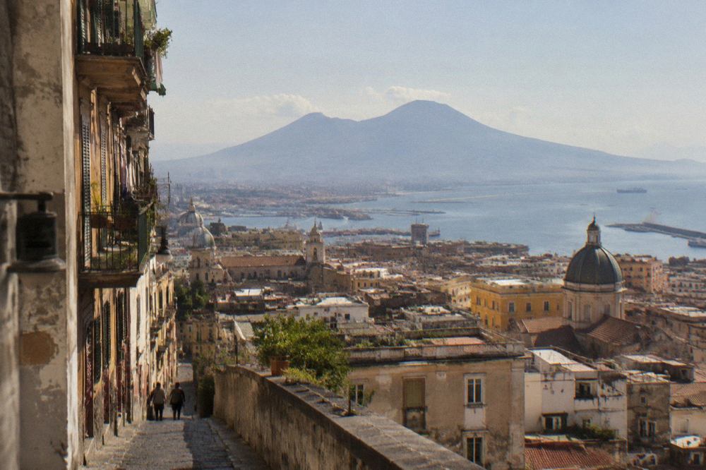 Aerial view of the Pompeii archaeological site with Mount Vesuvius in the background and the Bay of Naples beyond
