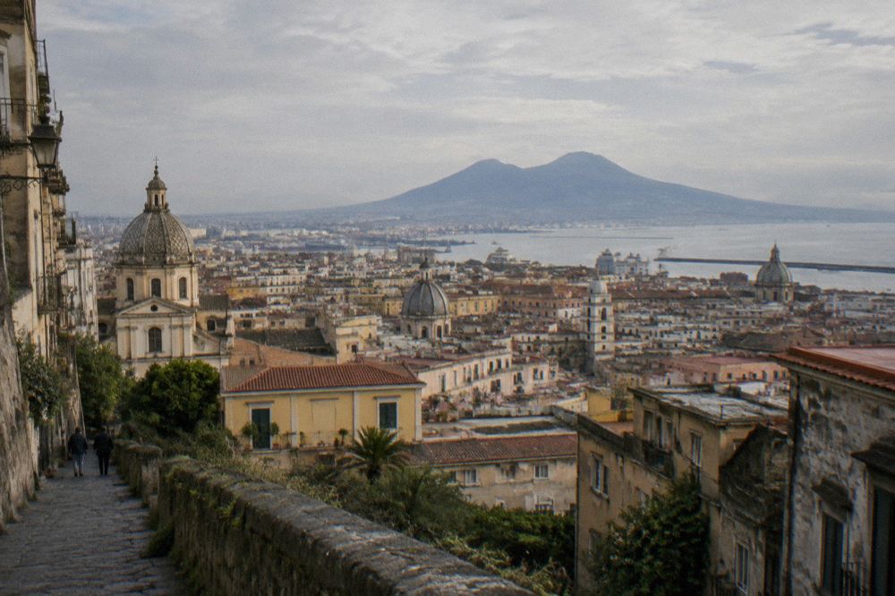 A stone terrace overlooking the Bay of Naples with Vesuvius on the horizon at dusk