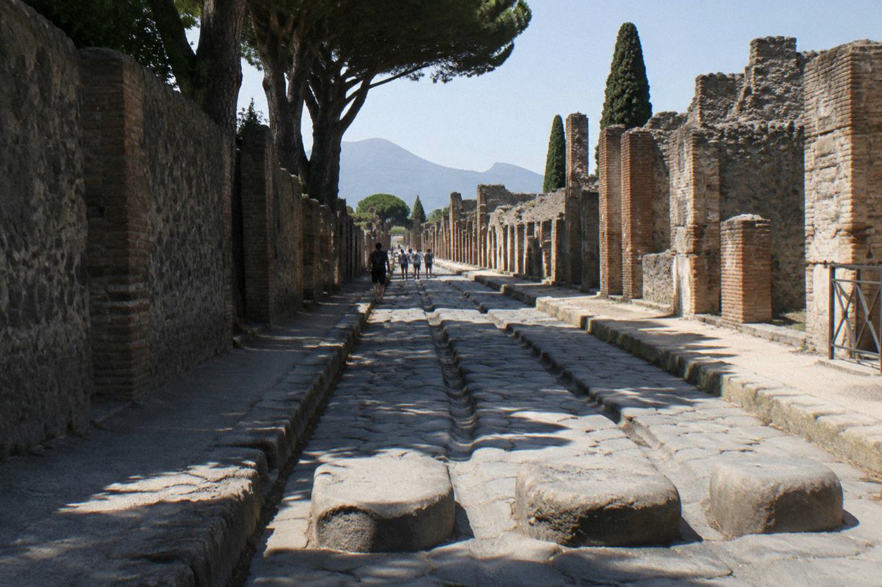 Roman stone columns standing among the excavated ruins of Pompeii under a clear sky