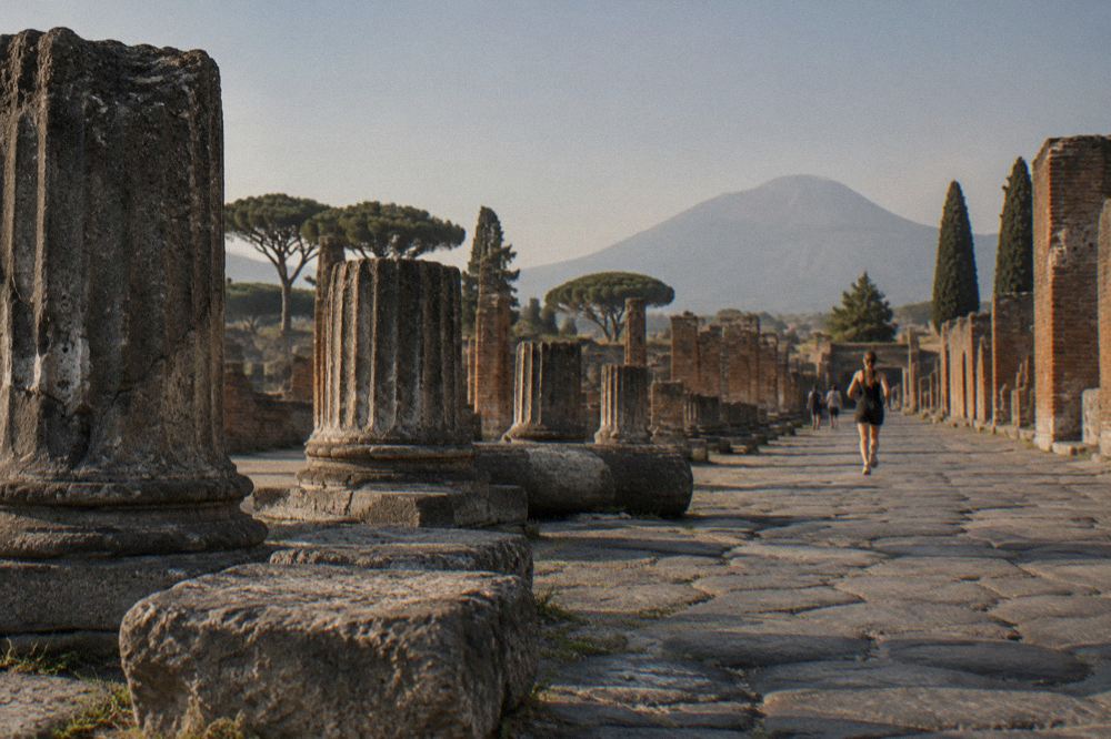 Weathered plaster casts of Pompeii victims displayed on a stone floor inside the archaeological park