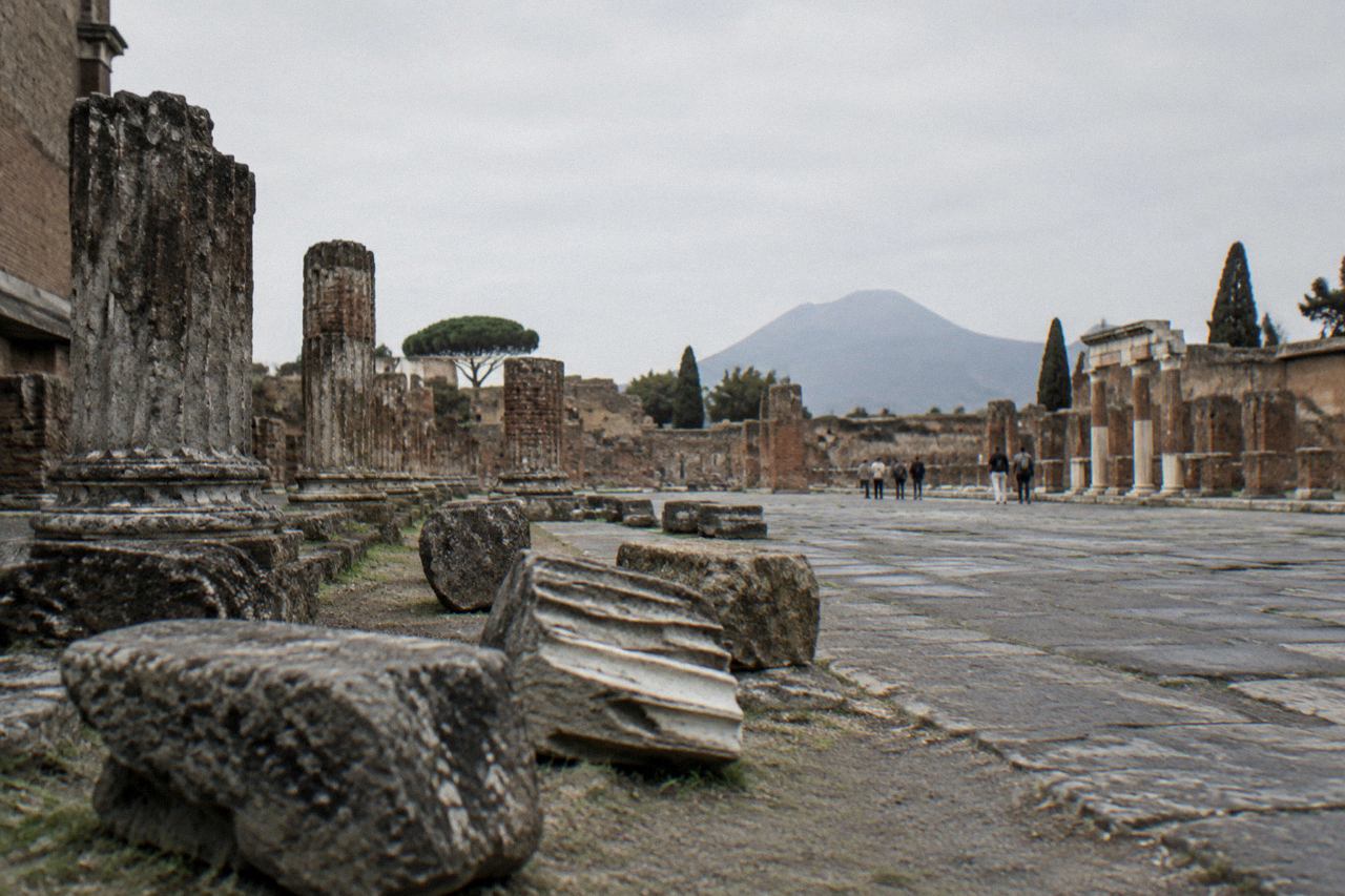 Ancient stone street in the Pompeii archaeological park with Mount Vesuvius on the horizon