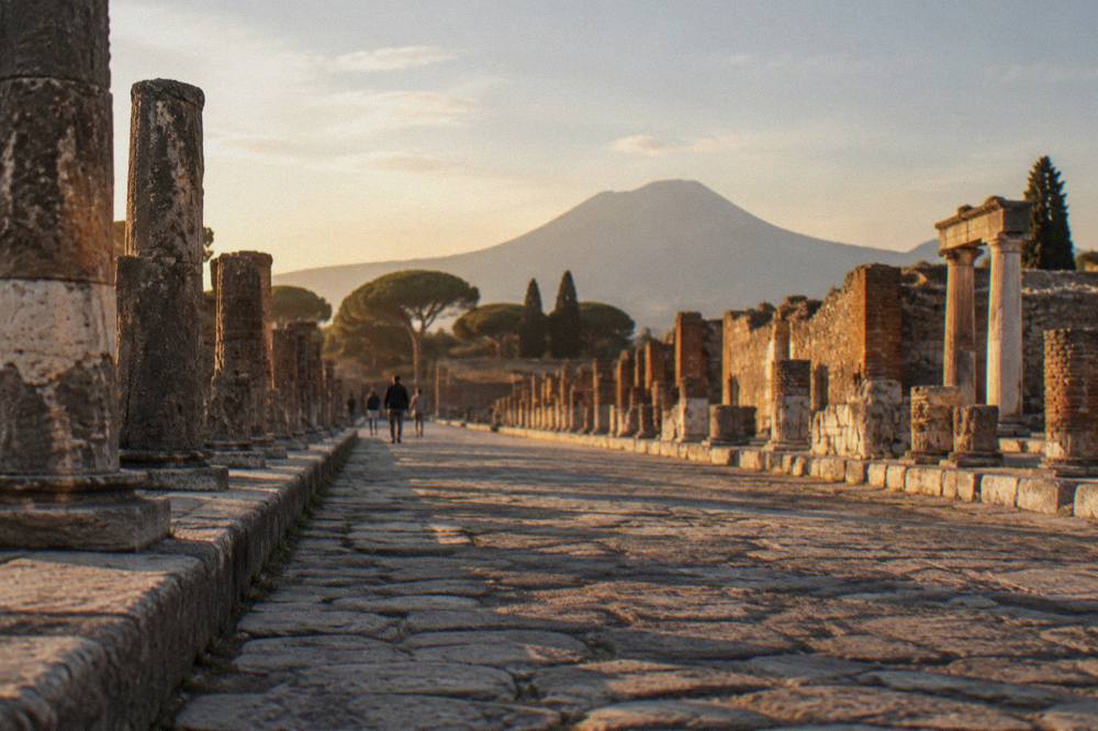 Ruined Roman walls and columns of Pompeii with the profile of Mount Vesuvius on the horizon