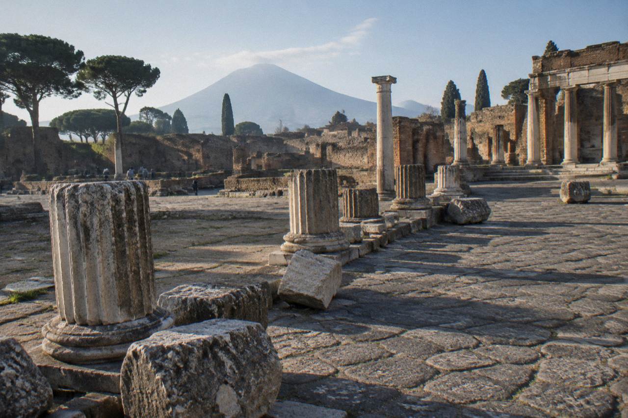 A stone-covered ancient street in Pompeii with worn Latin inscription panels set into a low wall