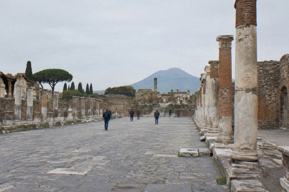 The crater rim of Mount Vesuvius under a hazy sky above the Bay of Naples
