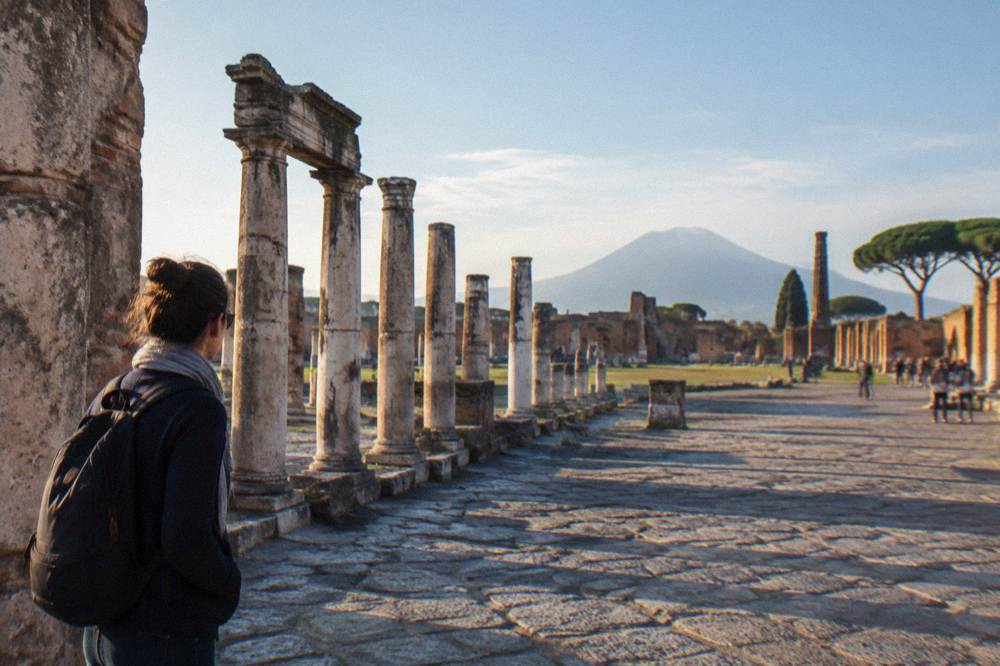 Ancient stone street with worn stepping stones under a low stone archway in the Roman city of Pompeii