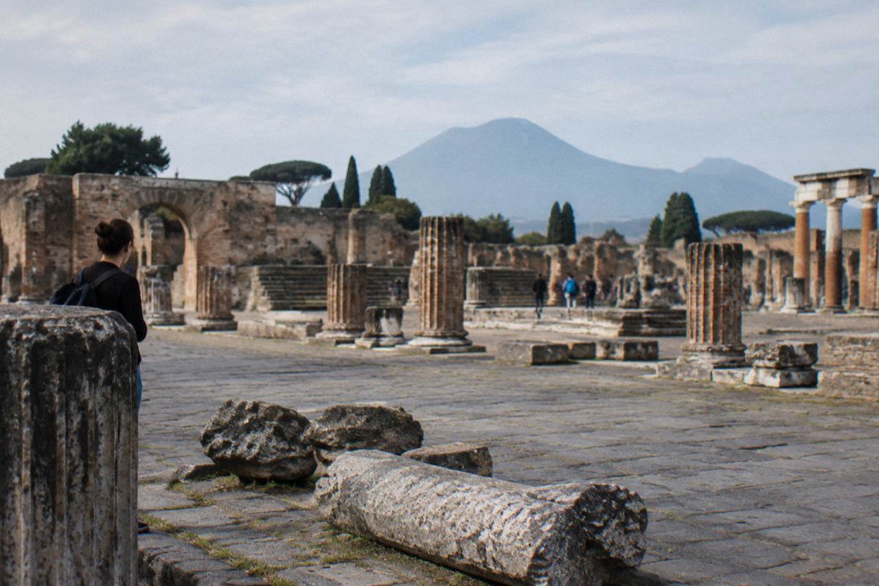 Ancient stone street with worn stepping stones under a low stone archway in the Roman city of Pompeii