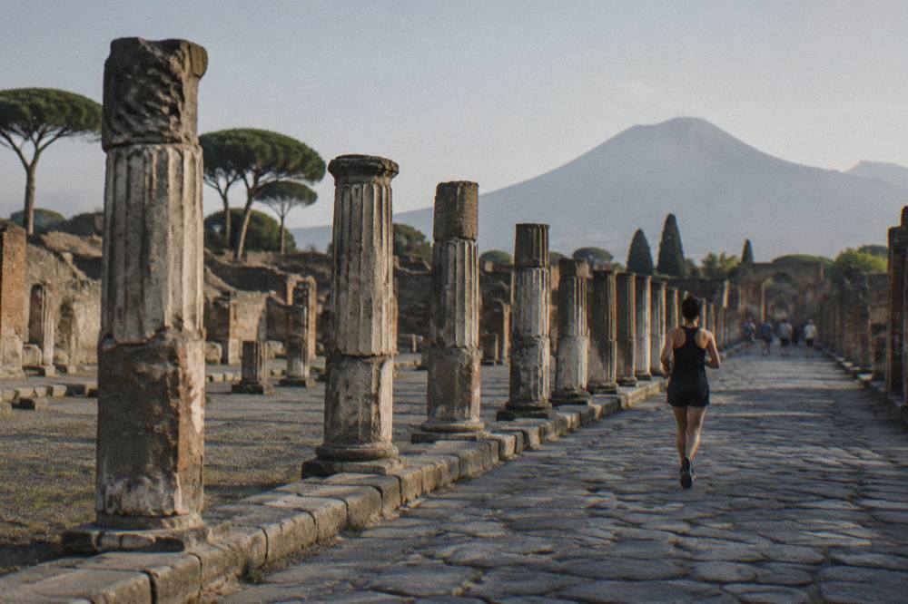 Ruin walls and plaster casts of eruption victims inside an excavated Pompeii enclosure