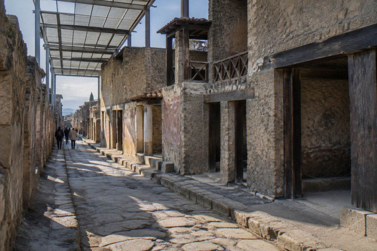 Stone walls and wooden doorframe of an ancient shopfront under open sky at Herculaneum