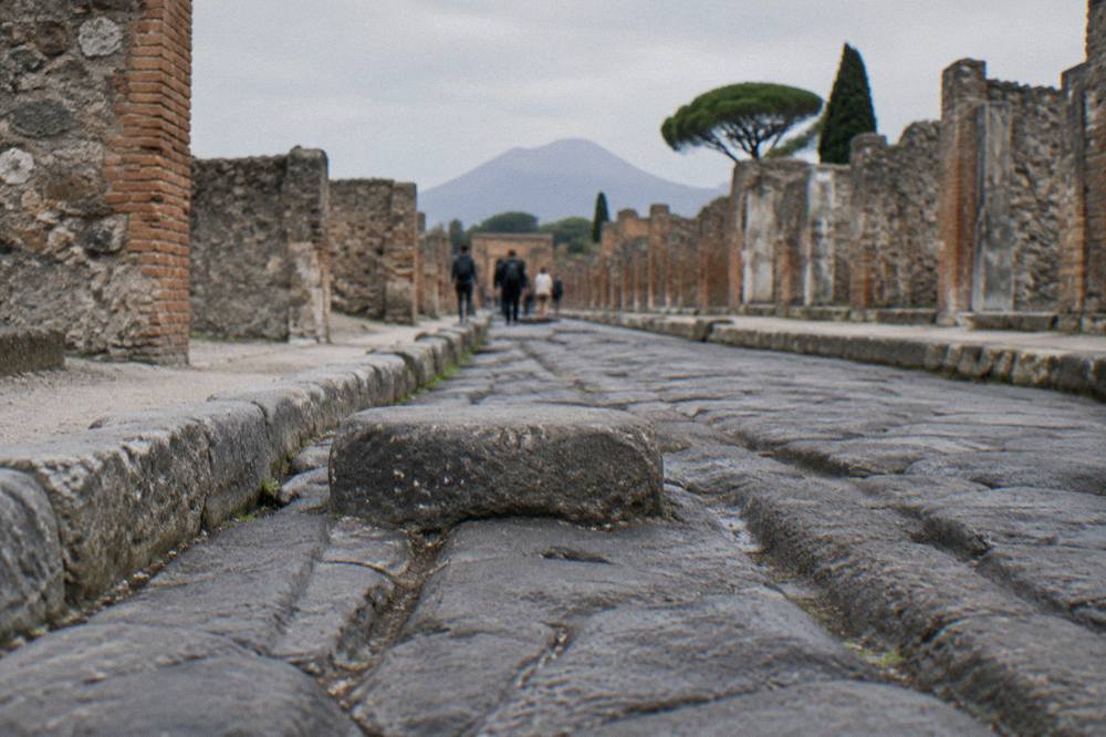 Frescoed wall emerging from volcanic debris inside an excavated Pompeii house