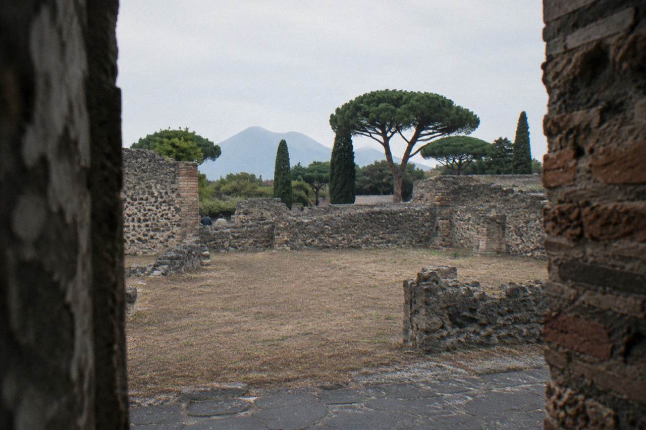 A stone street in the ancient Roman city of Pompeii with worn paving stones under an open sky