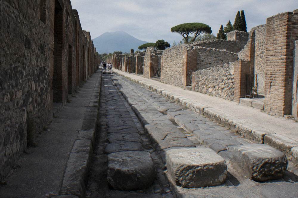 A quiet Roman villa courtyard with painted walls and empty stone channels