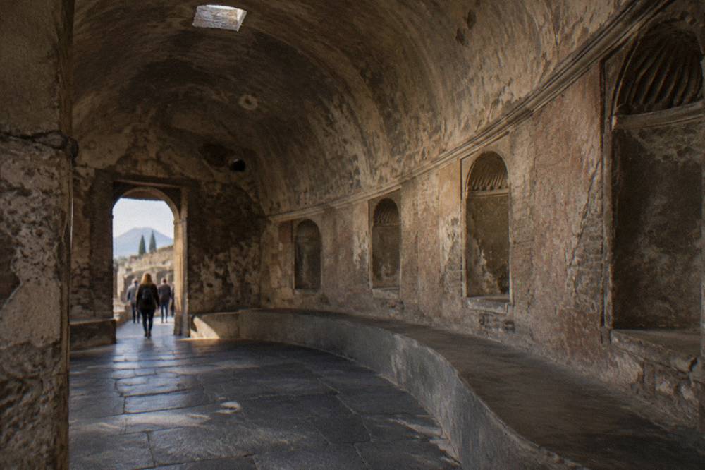 Sunlit interior of an ancient Roman bath complex with brick arches and worn stone floors