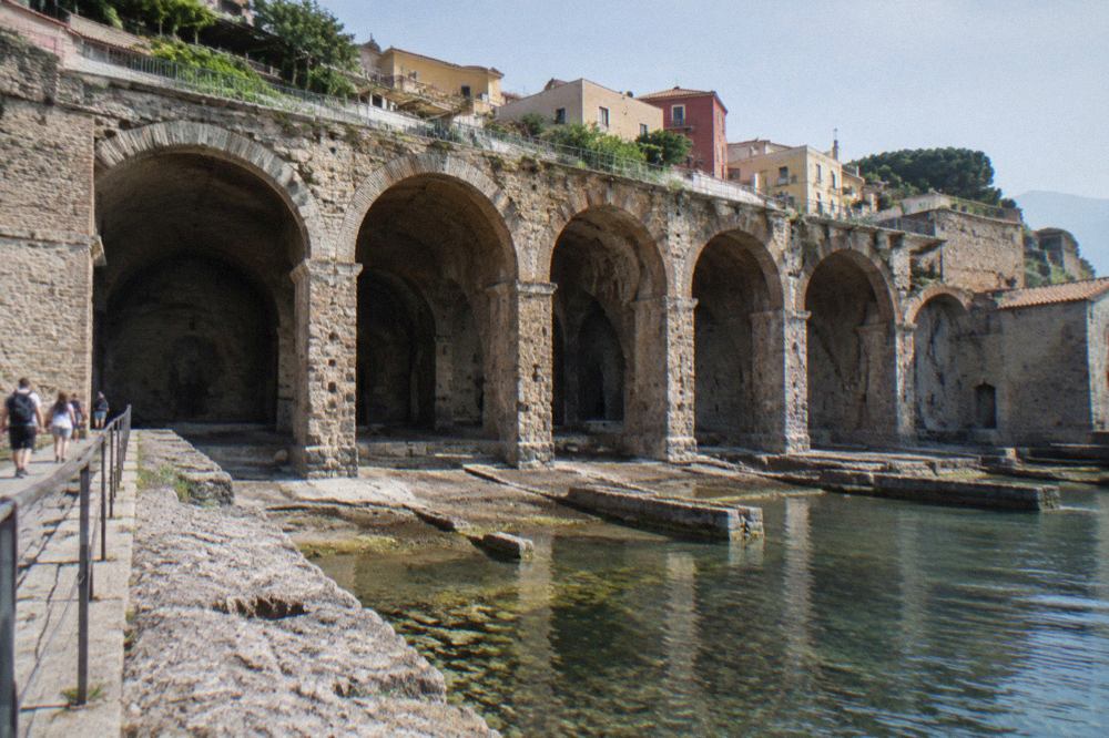 Row of stone vaulted archways opening onto the excavated ancient shoreline at Herculaneum