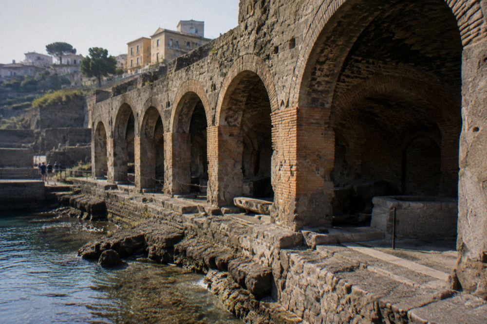 Repeated stone arches of the Herculaneum boat sheds seen along the ancient shoreline path