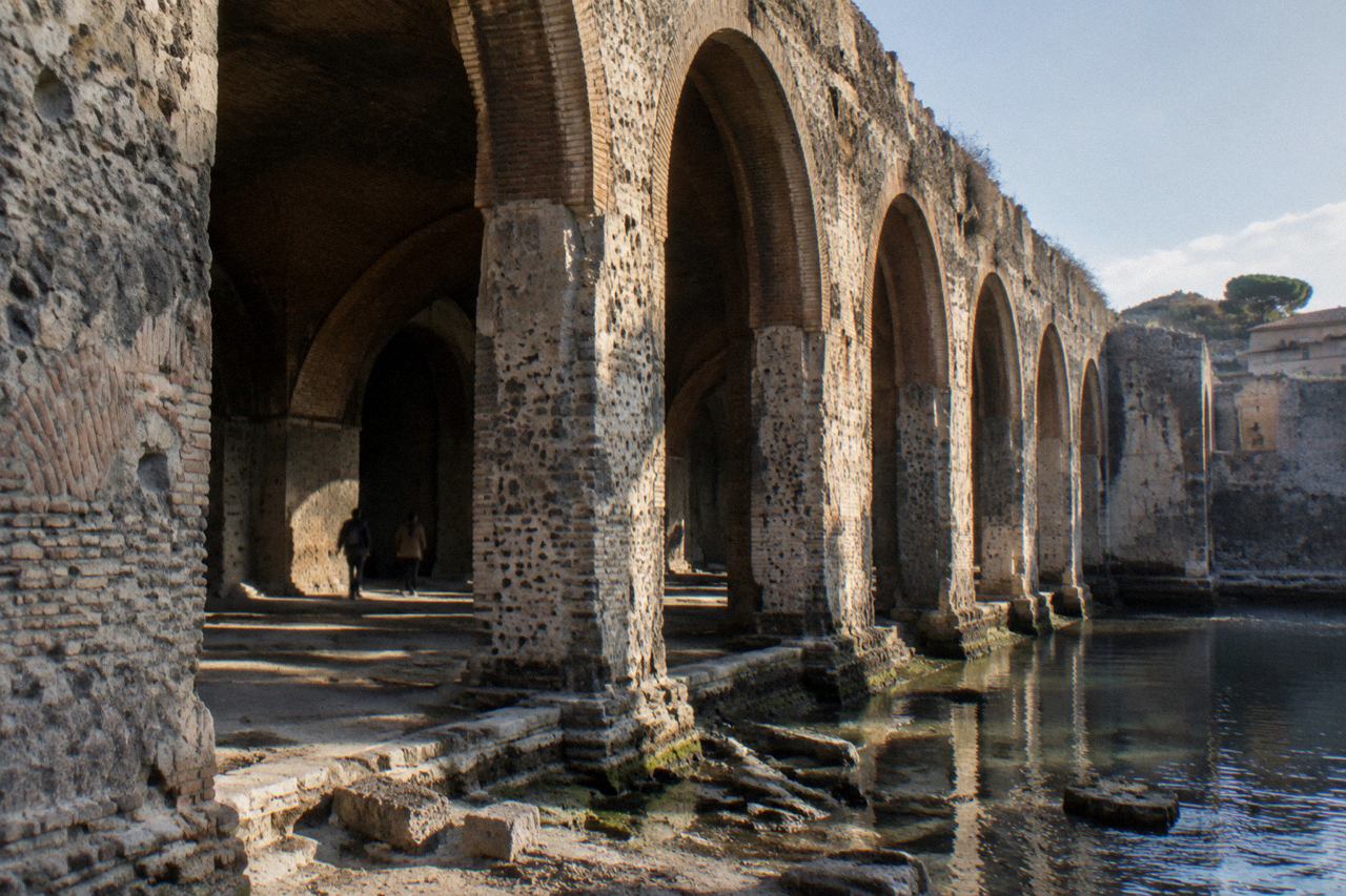 Row of stone vaulted archways opening onto the excavated ancient shoreline at Herculaneum