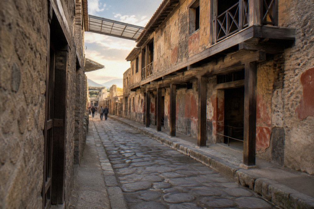 Row of Roman stone building fronts with dark carbonised wooden doorframes under bright sky