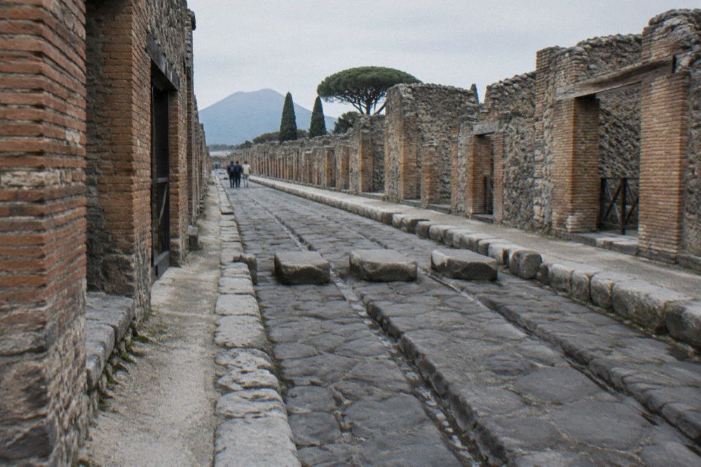 Narrow ancient street between high stone walls with worn cart ruts in the paving