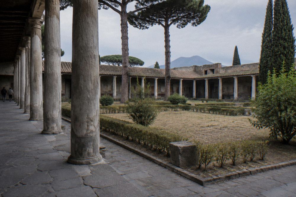 Group of visitors walking through an ancient Roman colonnade in Pompeii