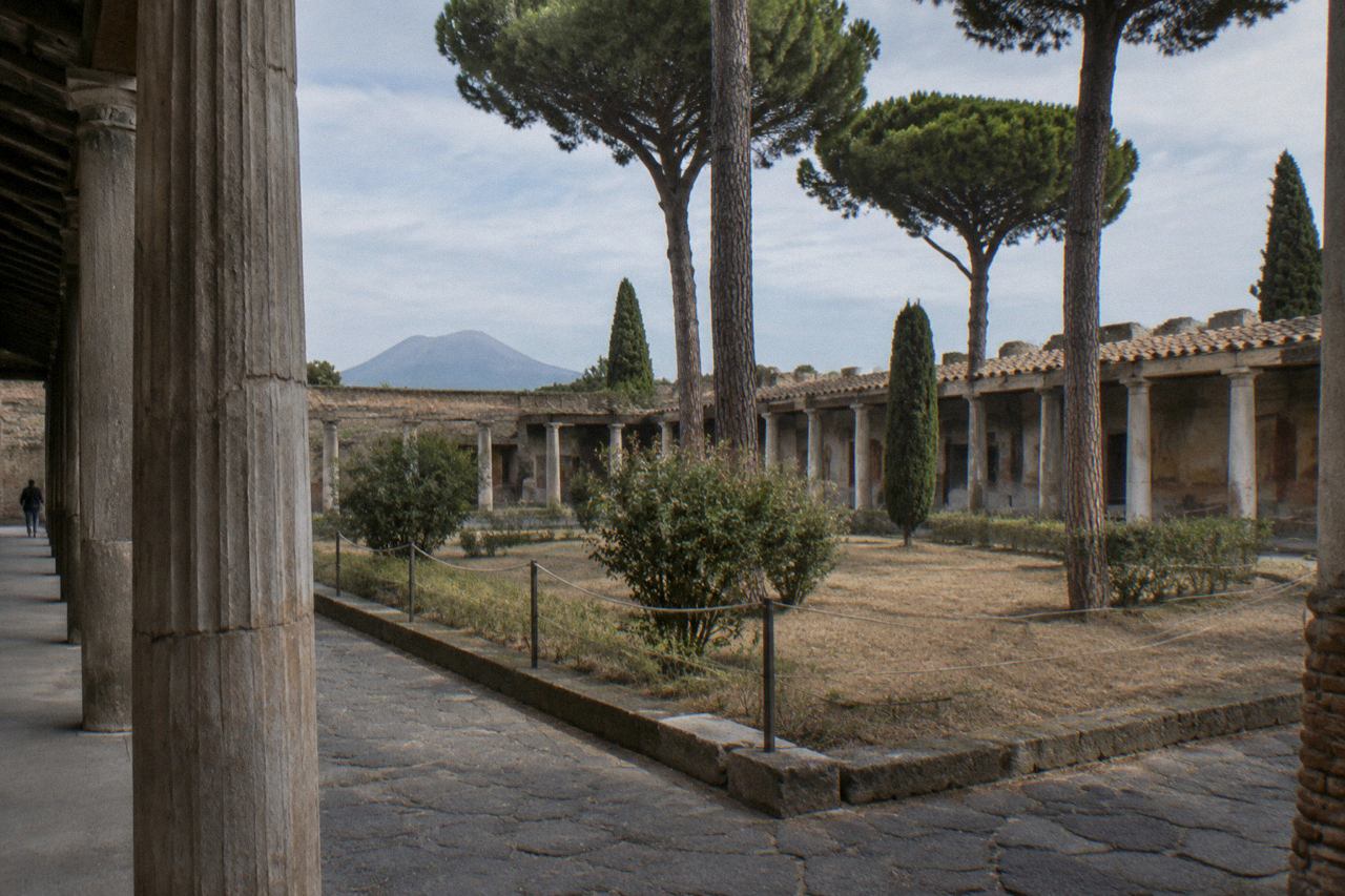 Ancient frescoed wall and stone doorway inside a Roman house in Pompeii