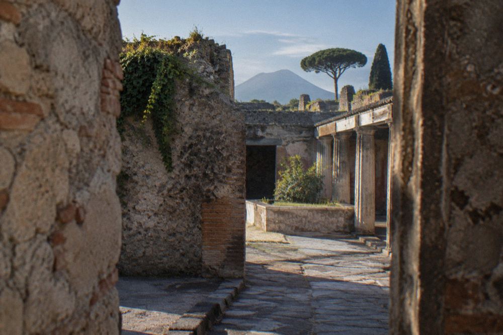Worn volcanic stone paving stones of an ancient Roman street lit by morning light