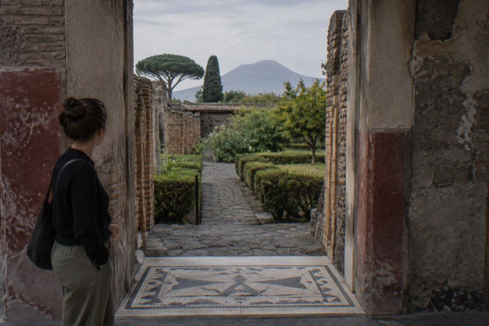 Worn stone-paved Roman street in Pompeii with ancient walls on both sides
