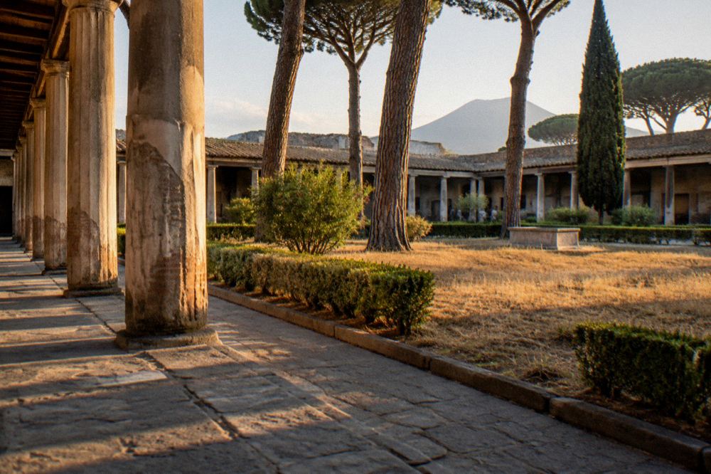 Row of stone columns along the ancient forum of Pompeii with Mount Vesuvius behind