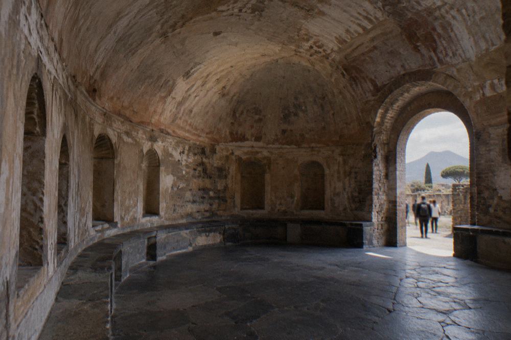 Roman garden courtyard with columns and green planting inside the Pompeii excavations