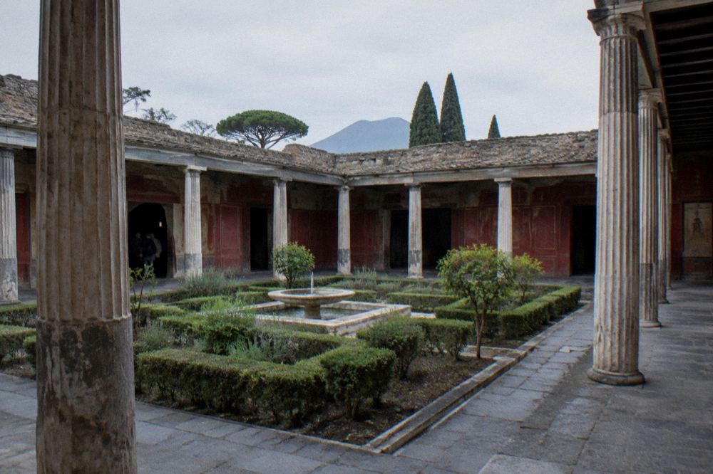 Sunlit ancient doorway in Pompeii with stone lintel and shaded interior beyond