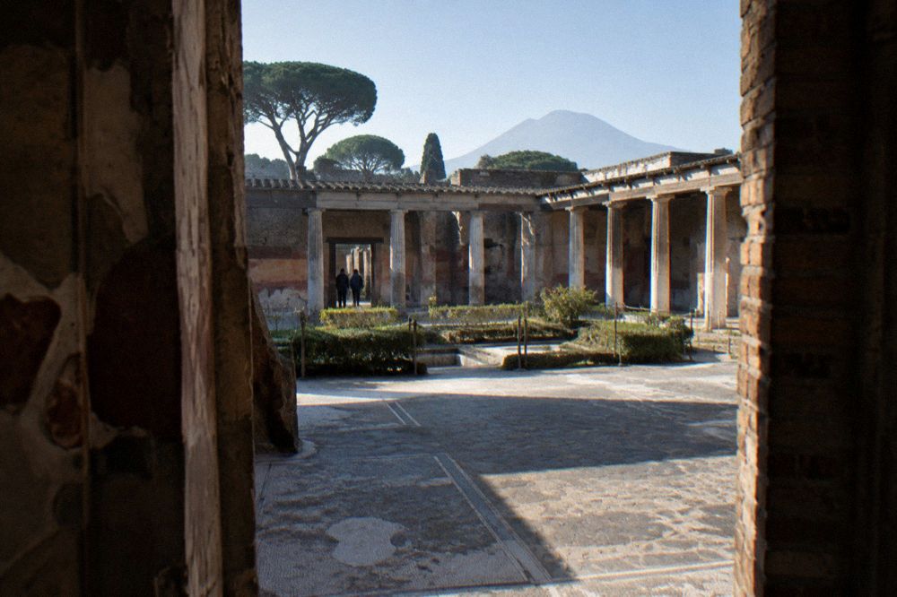 Railway platform beside the excavations at Pompei with station buildings and tracks