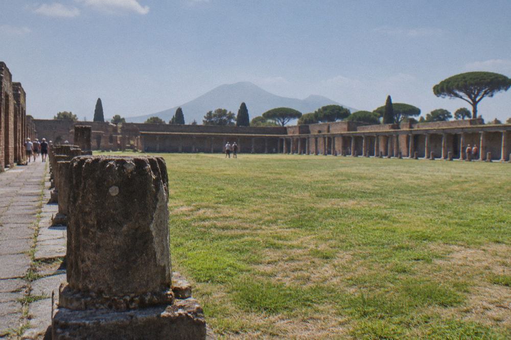 A wide stone-lined rectangular pool basin in the centre of a large ancient enclosure