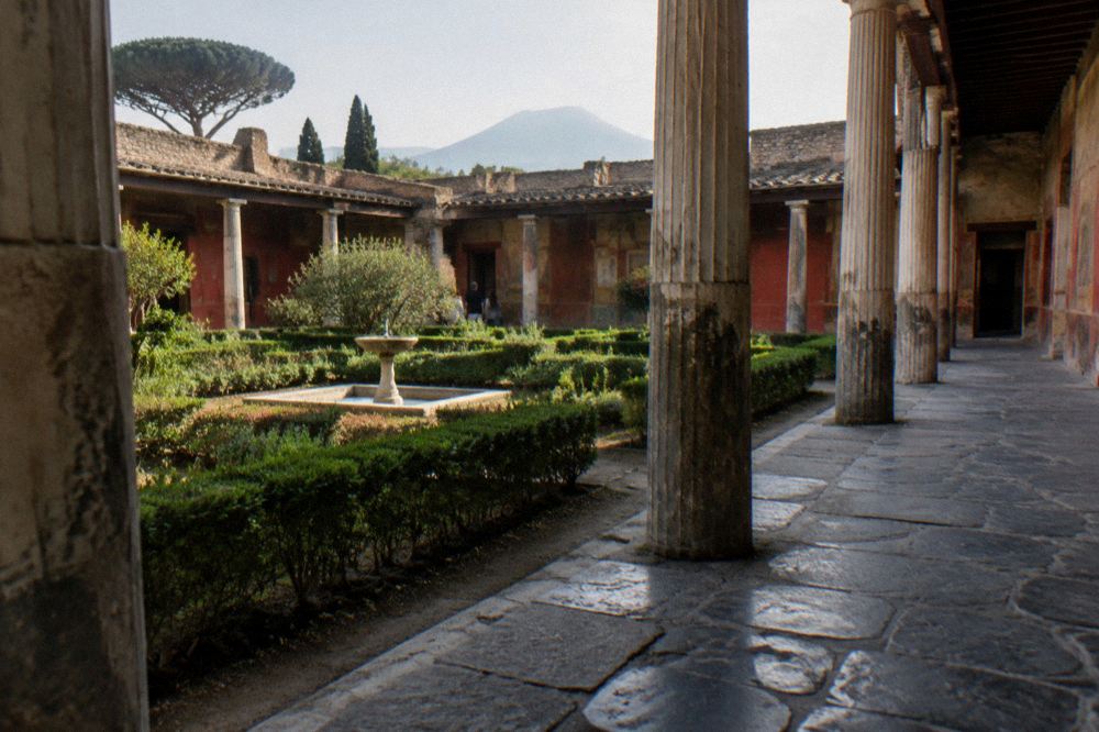 Late afternoon light on ancient Pompeii street walls with Vesuvius rising beyond the ruins