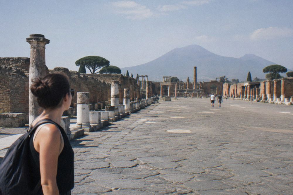 Rows of weathered stone steps descending toward the oval sandy floor of the ancient arena