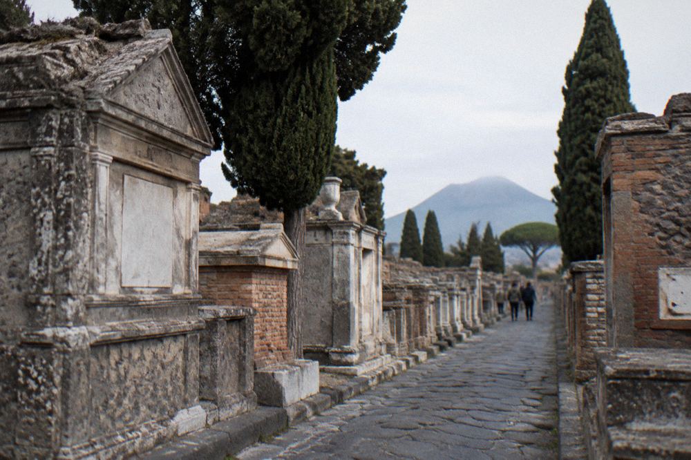 Curved stone bench tomb of a Roman family beside an ancient street in Pompeii