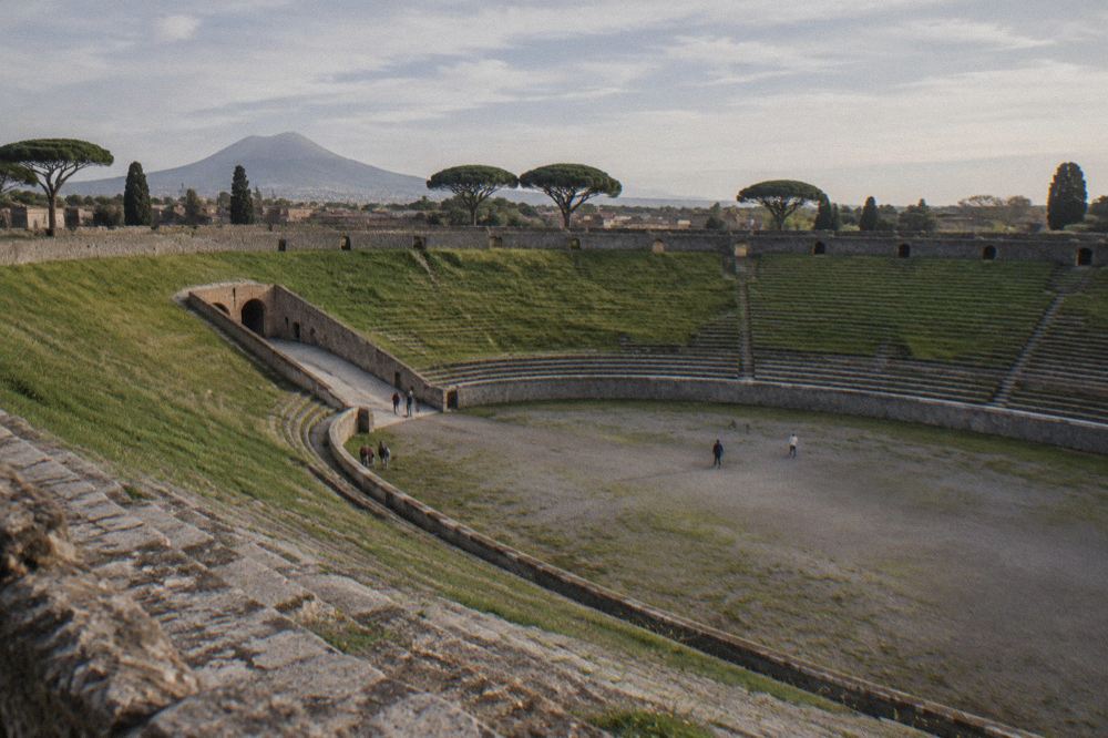 Stepping stones crossing a rutted ancient Roman street in Pompeii with stone walls either side