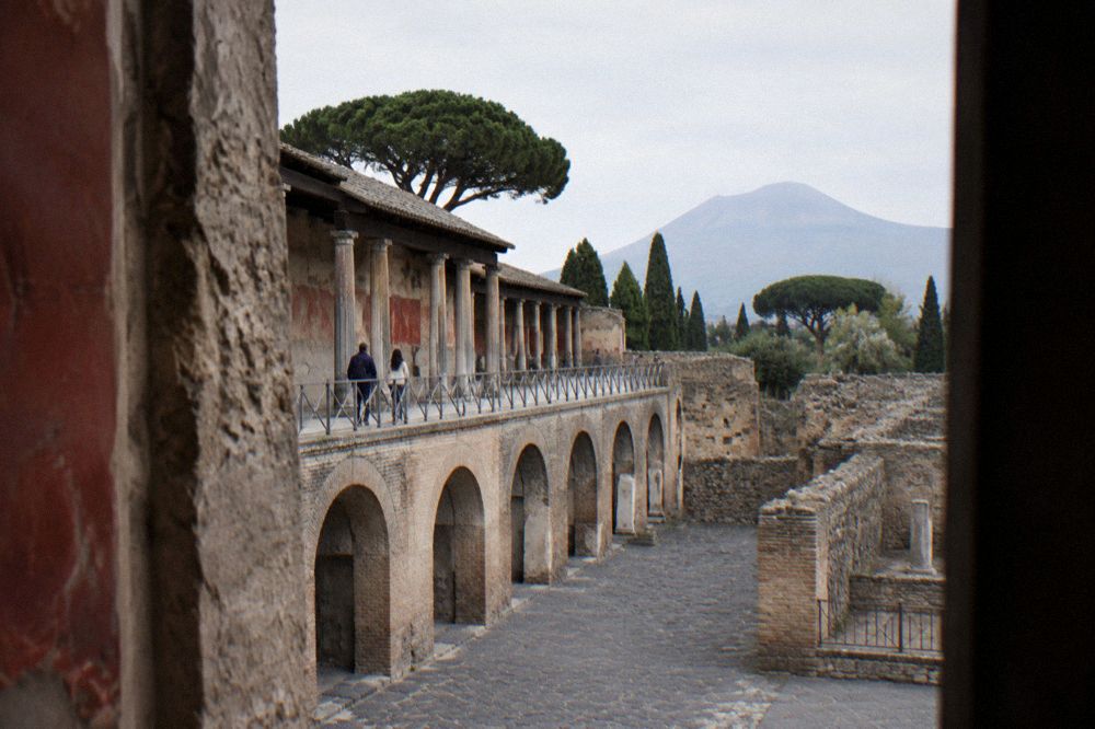 Ancient stone paving worn smooth, with low walls and a stone doorway under open sky