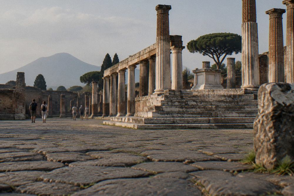 A long colonnade of columns in an ancient Roman villa ruin facing the sea